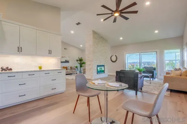 a kitchen with stainless steel appliances kitchen island granite countertop a stove a sink a dining table and chairs