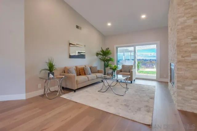 a living room with furniture a fireplace and a dining table with wooden floor