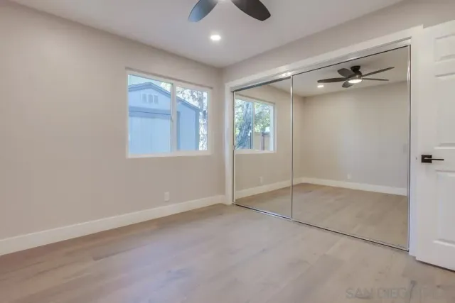 a front view of a house with a yard potted plants and large tree