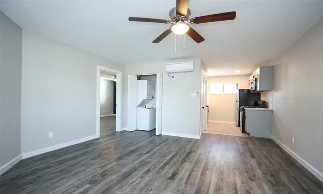 a view of a kitchen with a refrigerator a ceiling fan and wooden floor