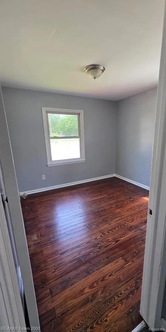 6646 Harding Street Taylor, MI 48180 - Photo 2 of 9 Room featuring wood-finish flooring, light gray walls, a single window, and a flush mount ceiling light fixture