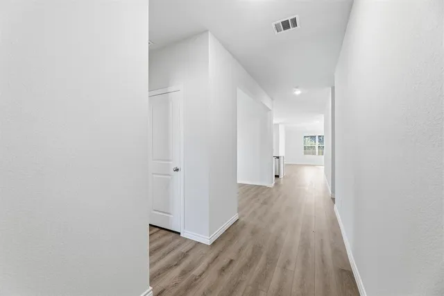 a view of a hallway with wooden floor