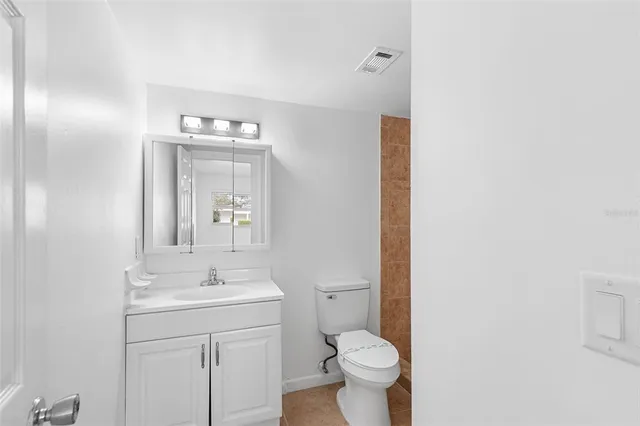 a bathroom with a toilet a sink and mirror