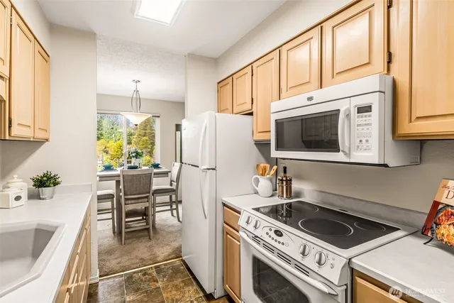 a kitchen with stainless steel appliances a stove a microwave a sink and white cabinets