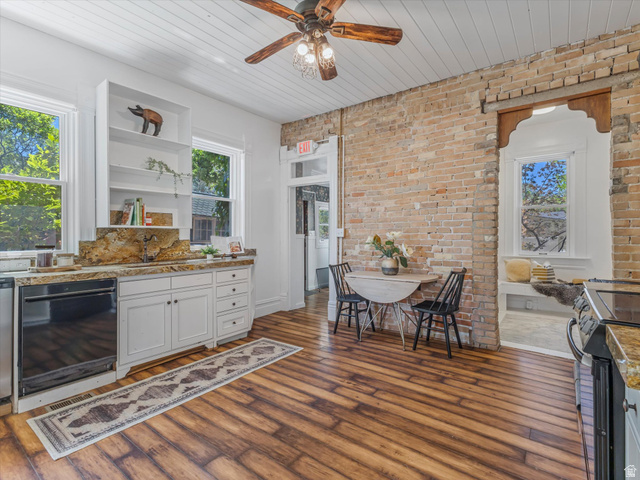 12825 South Fort Street Draper, UT 84020 - Photo 11 of 52 Kitchen featuring wood-finish flooring, exposed brick wall, white cabinetry with stone countertops, and a paneled ceiling with a ceiling fan