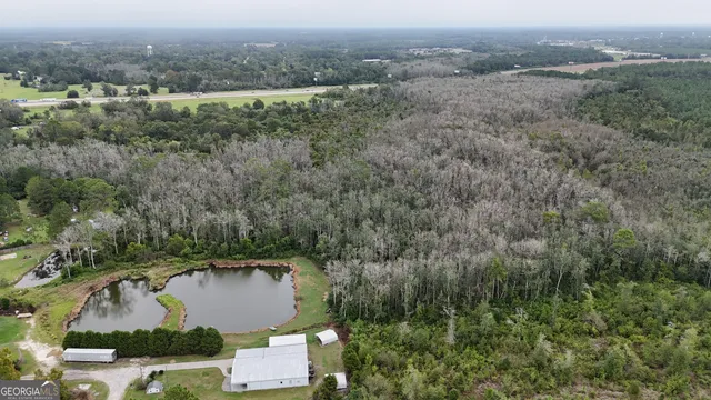an aerial view of residential houses with outdoor space and trees