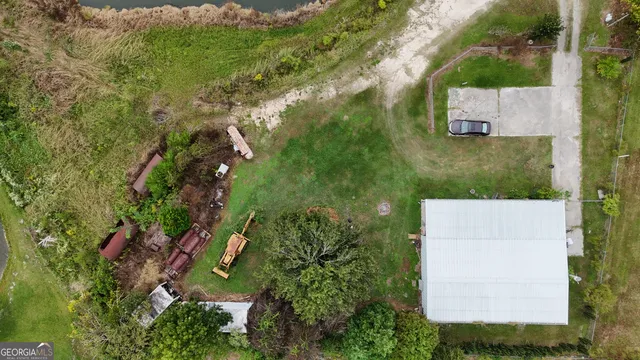 an aerial view of residential houses with outdoor space and trees