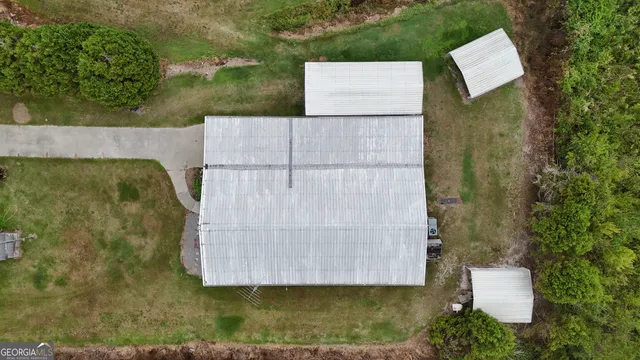 an aerial view of a house with a yard and large tree