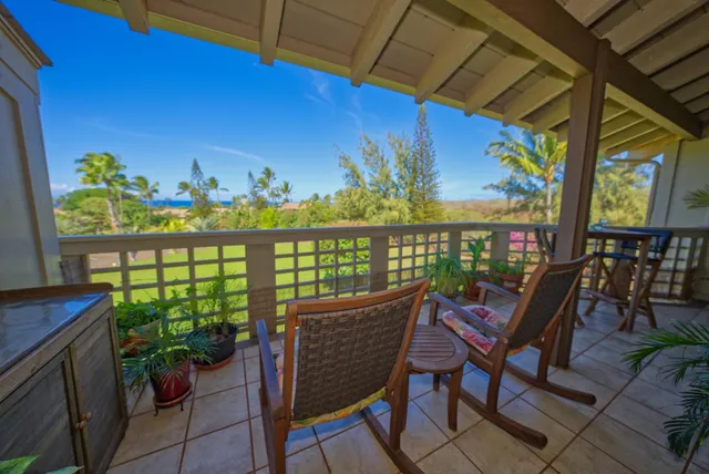 a view of a balcony with chairs and a potted plant
