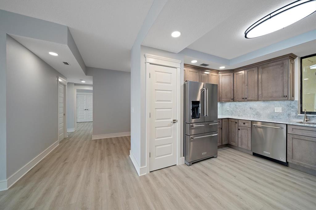 50 Coe Road, Unit 125 Belleair, FL 33756 - Photo 11 of 67 a kitchen with granite countertop a refrigerator and wooden cabinets