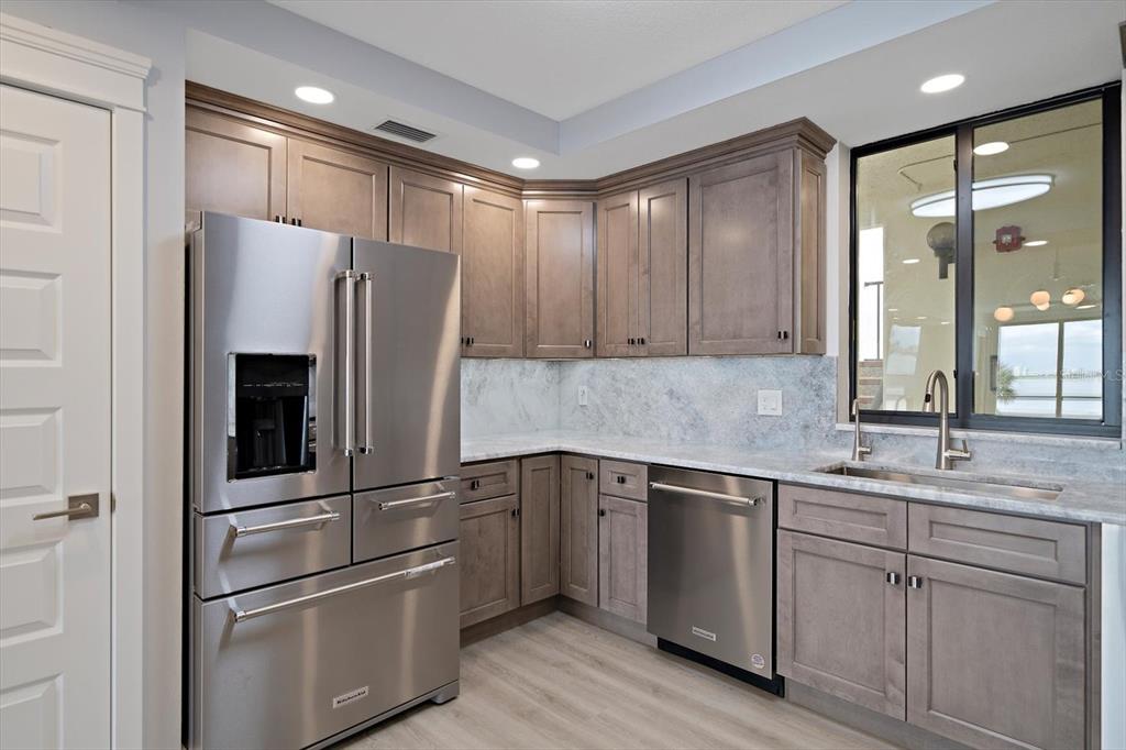 50 Coe Road, Unit 125 Belleair, FL 33756 - Photo 13 of 67 a kitchen with white cabinets and stainless steel appliances