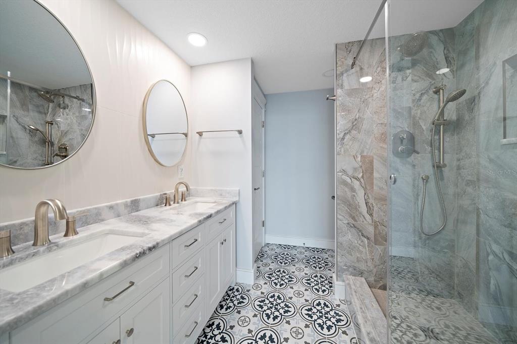 50 Coe Road, Unit 125 Belleair, FL 33756 - Photo 26 of 67 a bathroom with a double vanity sink mirror and shower