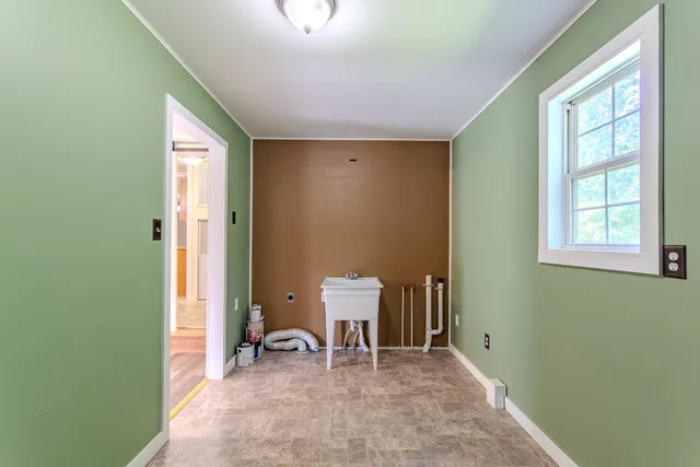 a view of a hallway to a room with windows
