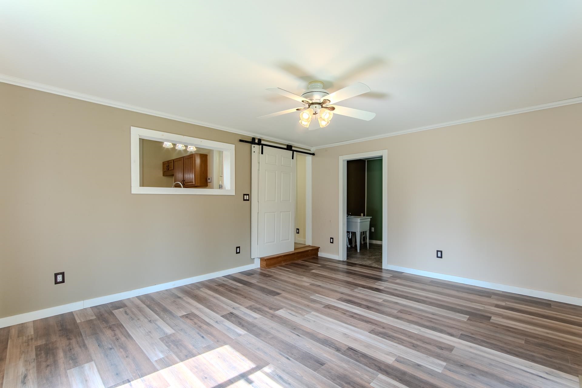 23 Old Ferry Road Bath Springs, TN 38311 - Photo 8 of 40 a view of a room with wooden floor and ceiling fan