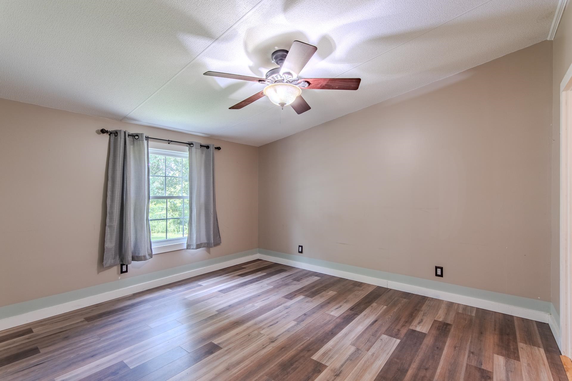23 Old Ferry Road Bath Springs, TN 38311 - Photo 9 of 40 wooden floor in an empty room with a window