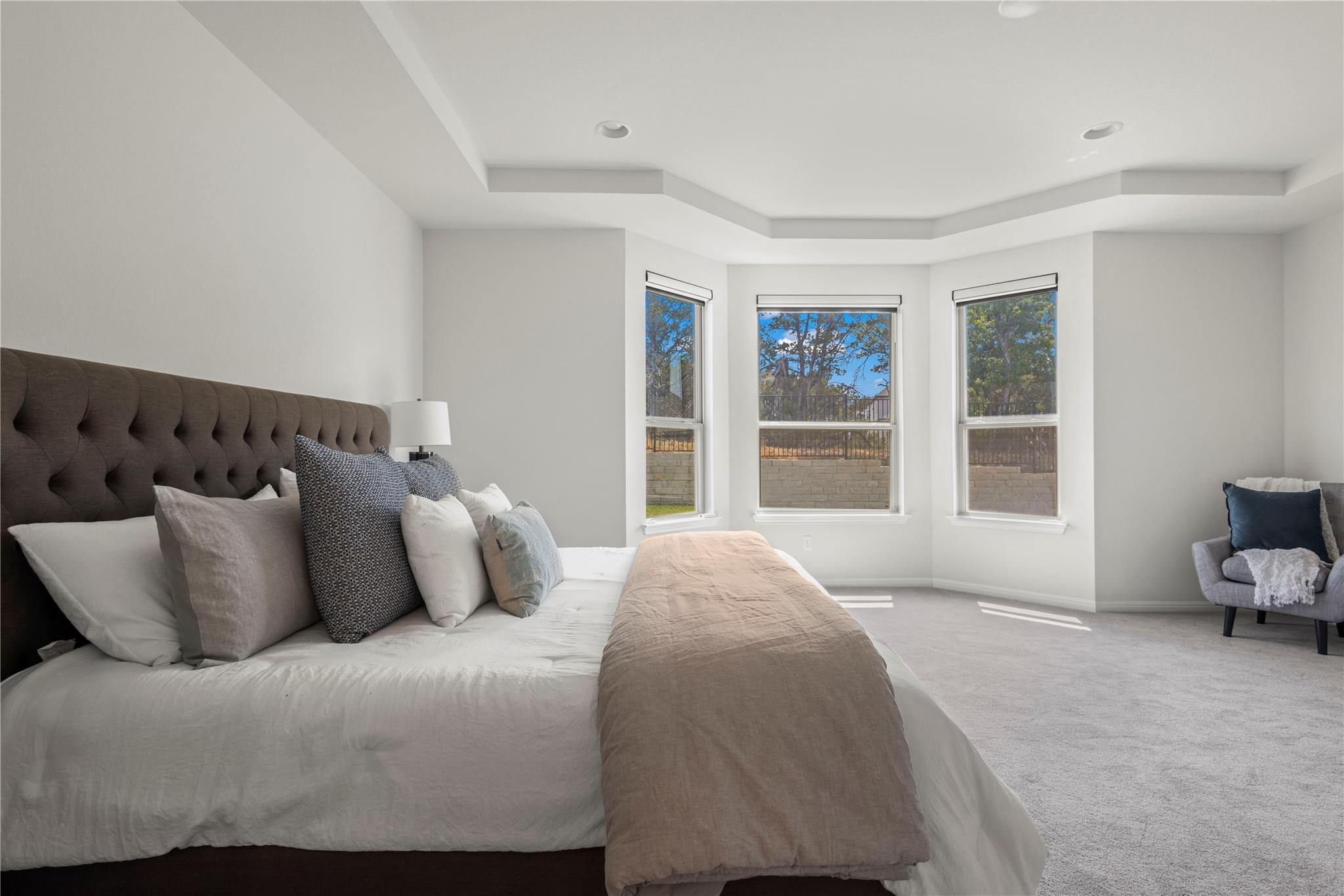 1128 Villa Rialto View Leander, TX 78641 - Photo 27 of 40 A spacious bedroom offers a large bay window with picturesque views and soft, neutral carpeting.