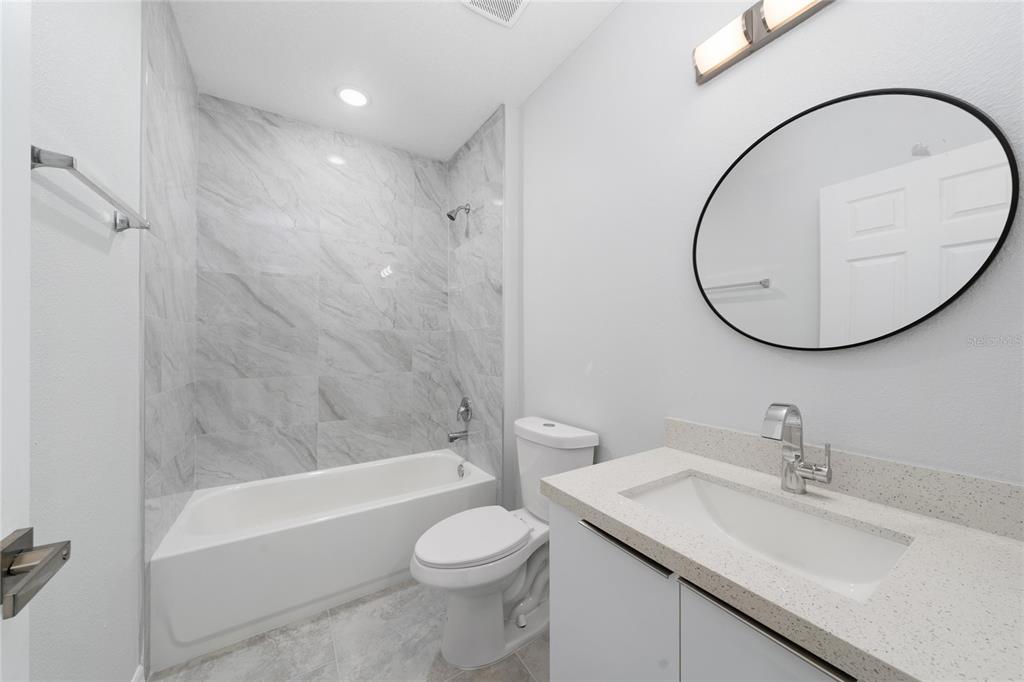 1427 Johnson Street Eustis, FL 32726 - Photo 8 of 25 a bathroom with a sink a toilet and a mirror