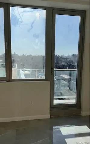 a view of a room with a large window and wooden floor