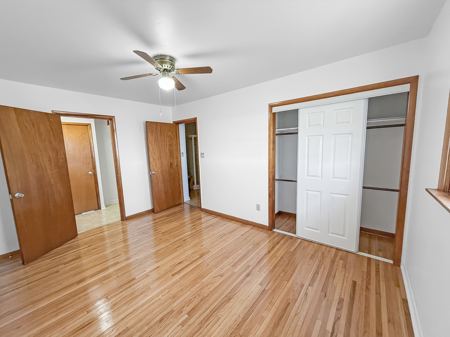 1165 North Henderson Road Freeport, IL 61032 - Photo 17 of 26 an empty room with wooden floor and a ceiling fan