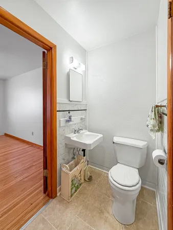 a bathroom with a toilet a sink and mirror