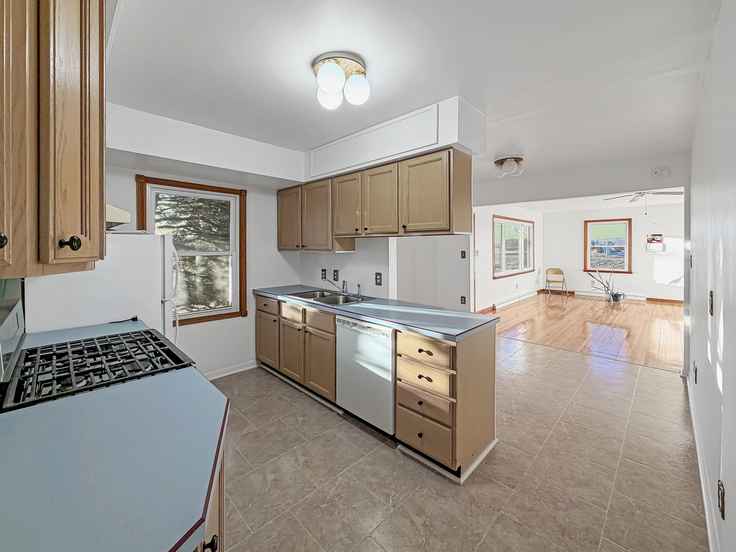 1165 North Henderson Road Freeport, IL 61032 - Photo 6 of 26 a kitchen with stainless steel appliances granite countertop a stove a sink dishwasher a refrigerator and white cabinets with wooden floor