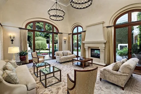 a living room with furniture a fireplace and a floor to ceiling window