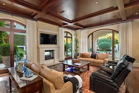 a living room with furniture a fireplace and a floor to ceiling window