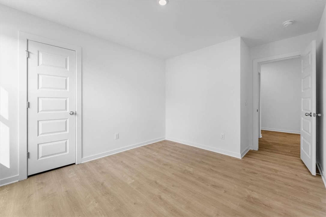 550 Riggs Street Prairie Grove, AR 72753 - Photo 14 of 29 Wood-finish flooring, white walls, white trim, and white paneled doors