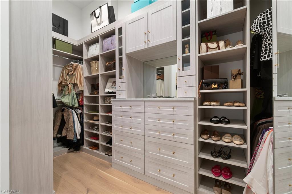 3290 Crayton Road Naples, FL 34103 - Photo 22 of 50 a view of walk in closet with clothes and shoes