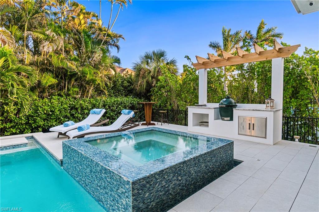 3290 Crayton Road Naples, FL 34103 - Photo 36 of 50 a view of a swimming pool with a patio