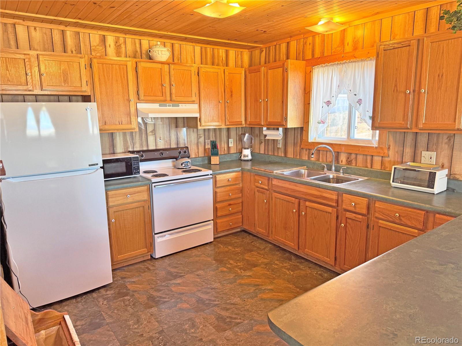 62 Rubel Road Westcliffe, CO 81252 - Photo 24 of 38 a kitchen with stainless steel appliances granite countertop a stove a sink and a refrigerator