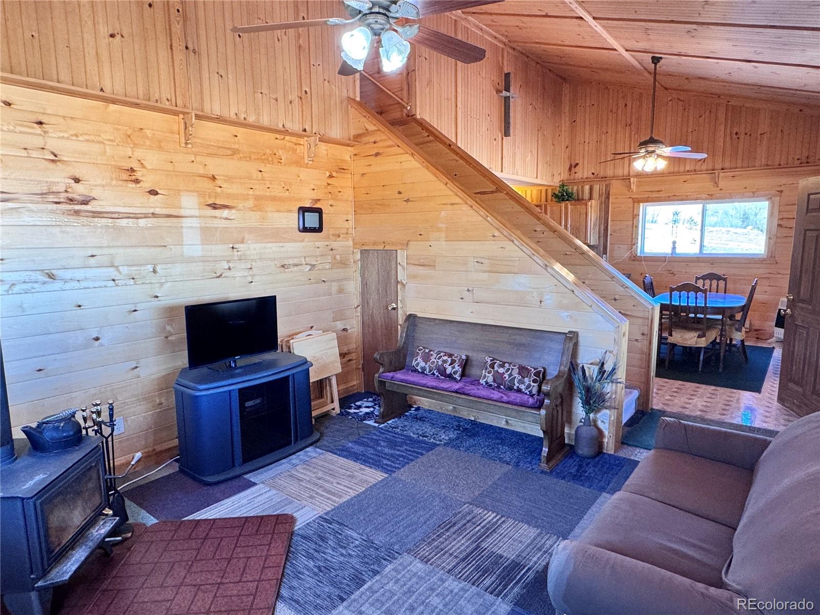 62 Rubel Road Westcliffe, CO 81252 - Photo 27 of 38 a living room with furniture a rug and a fireplace