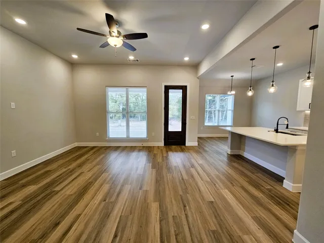 a view of a room with wooden floor and a ceiling fan