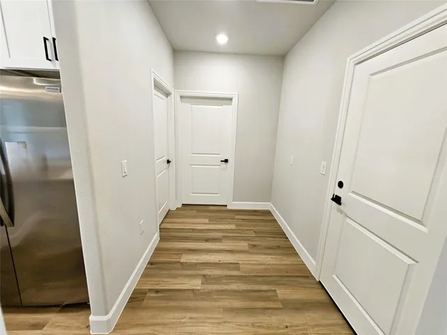 a view of a hallway with wooden floor