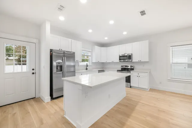 a kitchen with refrigerator a sink and cabinets