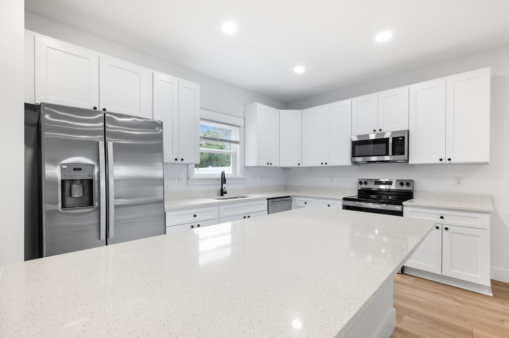 863 West 12th Street St. Augustine, FL 32084 - Photo 16 of 41 a kitchen with refrigerator a microwave a sink and cabinets