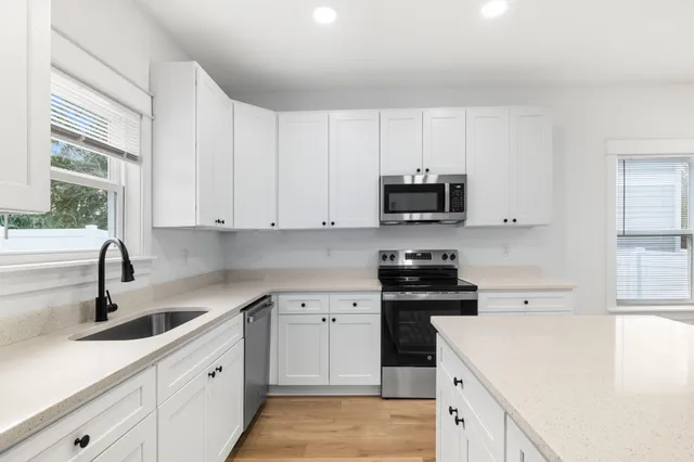 a kitchen with white cabinets and appliances