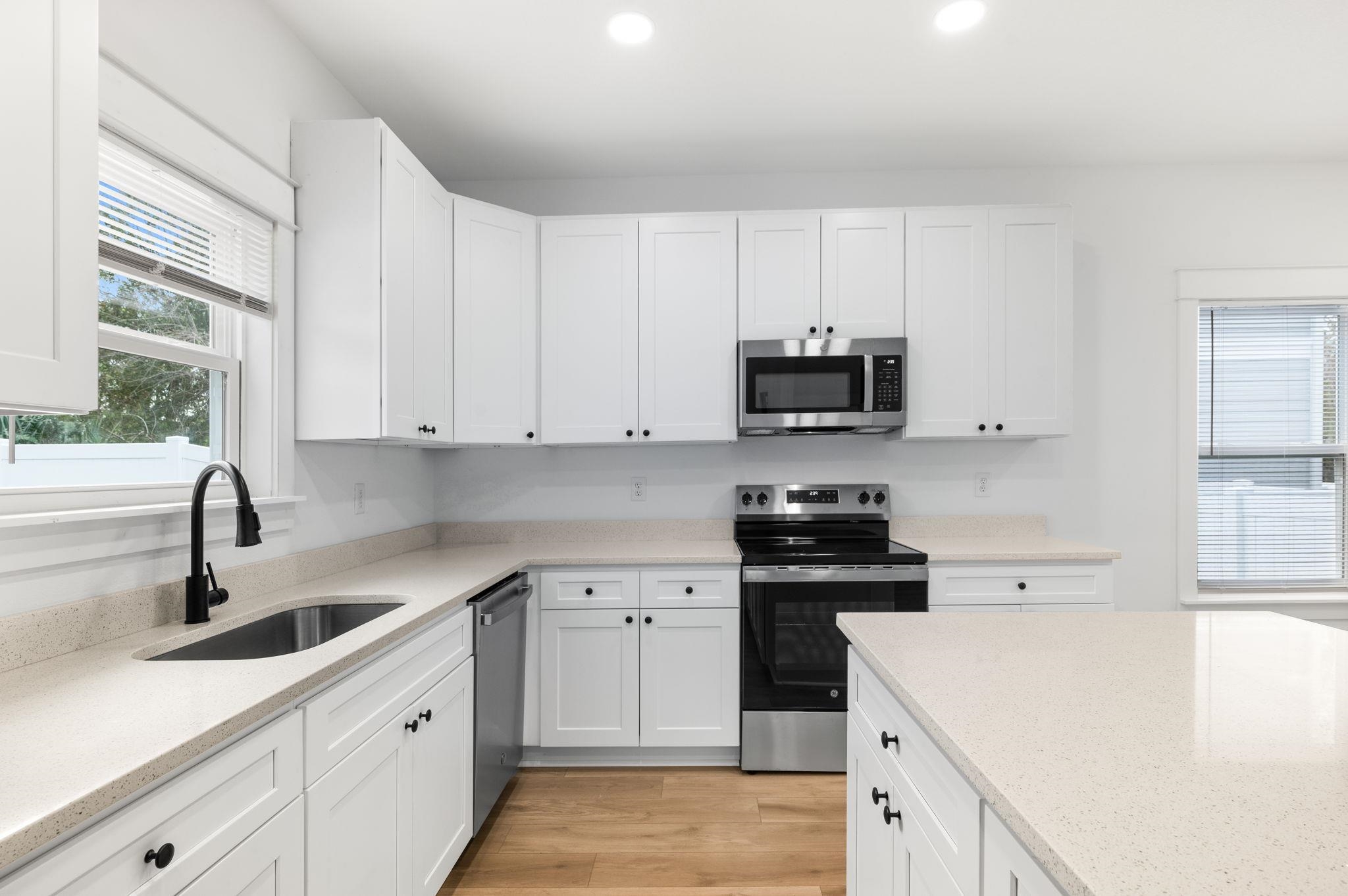 863 West 12th Street St. Augustine, FL 32084 - Photo 17 of 41 a kitchen with white cabinets and appliances