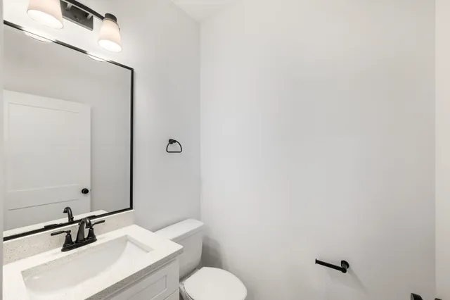 a bathroom with a sink toilet and mirror