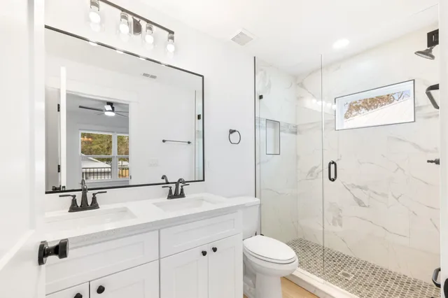 a bathroom with a sink a toilet a shower and a mirror