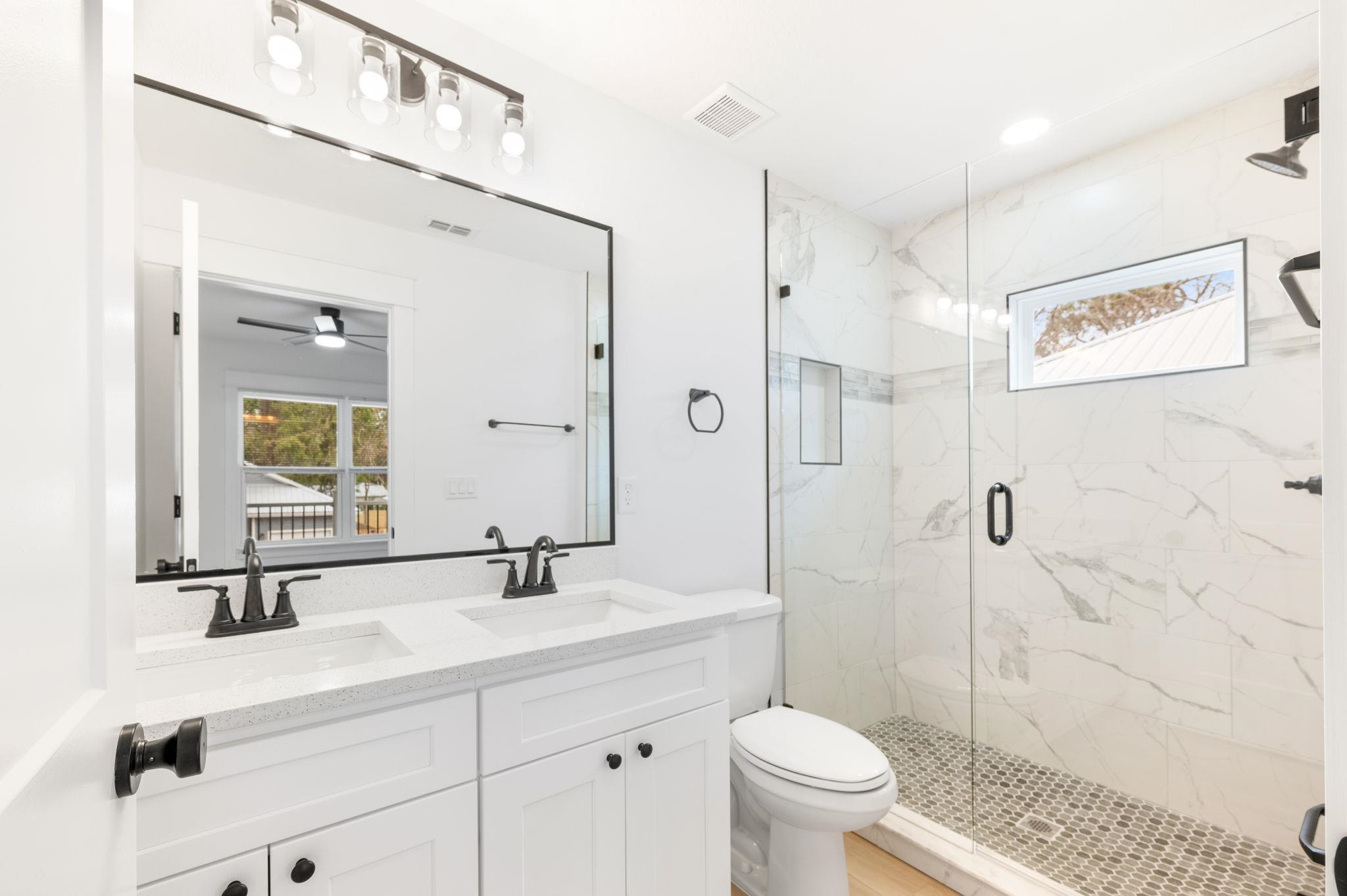 863 West 12th Street St. Augustine, FL 32084 - Photo 27 of 41 a bathroom with a sink a toilet a shower and a mirror