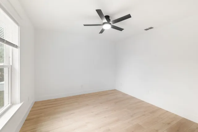 a view of empty room with wooden floor