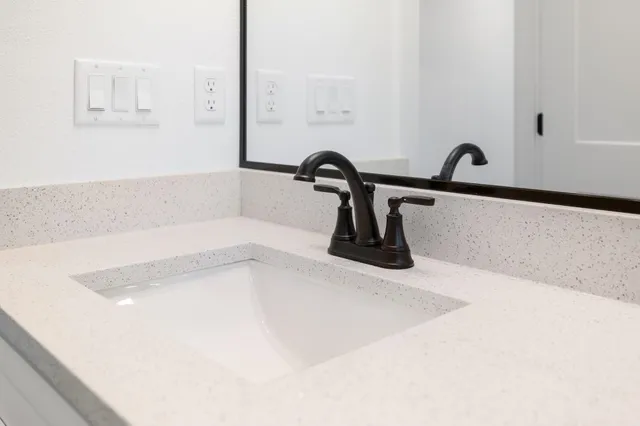 an empty room with wooden floor ceiling fan and windows