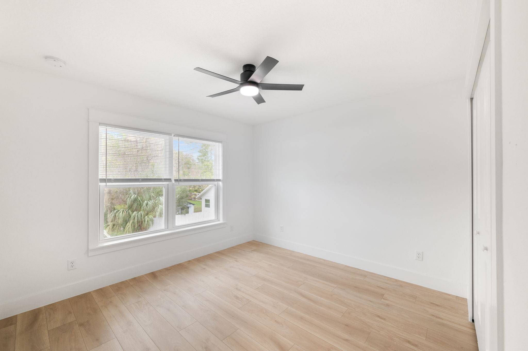 863 West 12th Street St. Augustine, FL 32084 - Photo 40 of 41 an empty room with wooden floor ceiling fan and windows