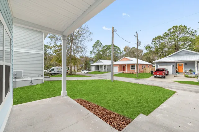 a view of a house with backyard and a tree