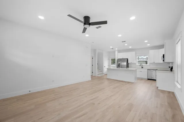a view of kitchen with kitchen island stainless steel appliances refrigerator oven and cabinets