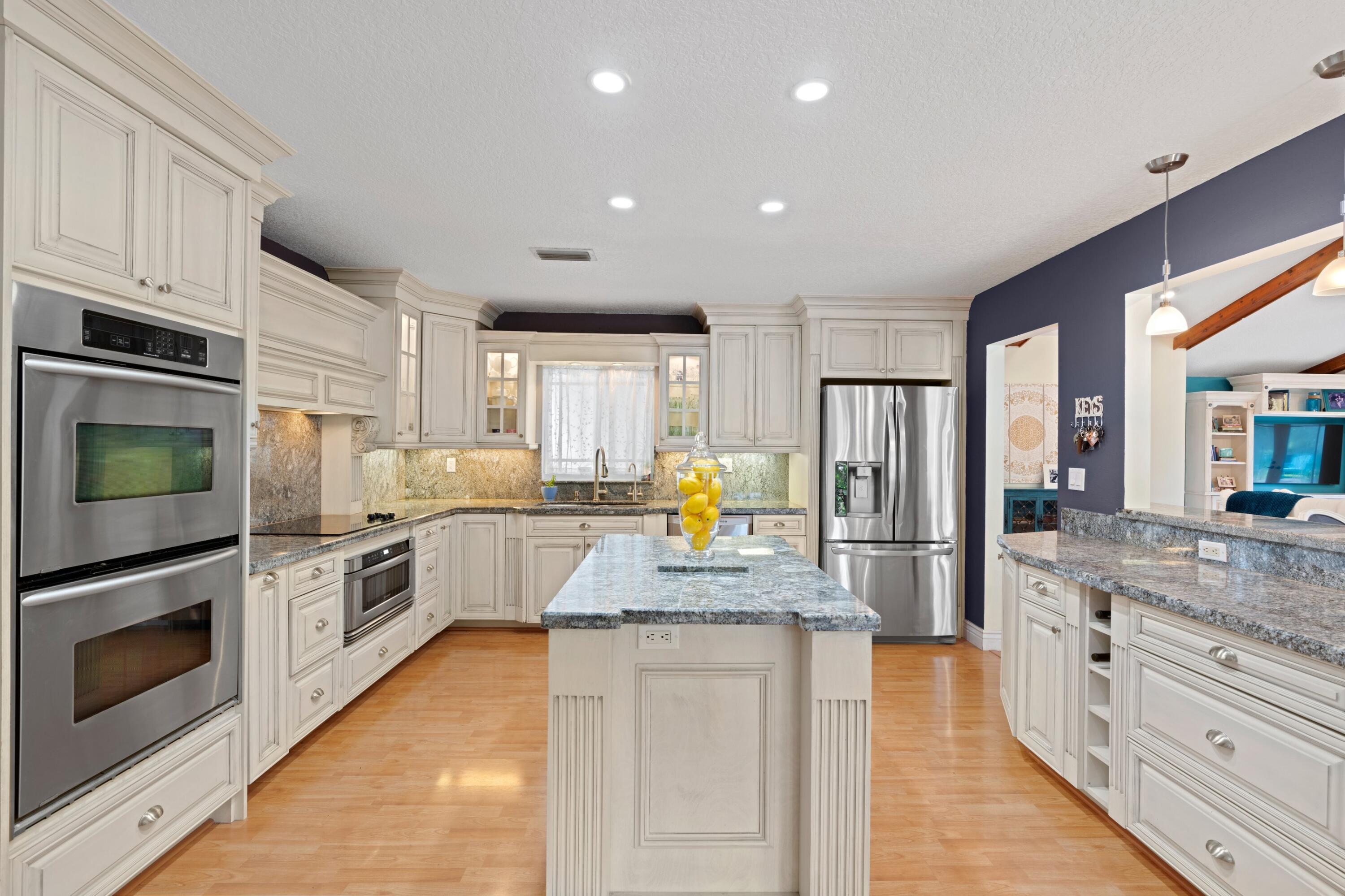 10238 Crosswind Road Boca Raton, FL 33498 - Photo 13 of 42 a kitchen with stainless steel appliances granite countertop a stove refrigerator sink and cabinets