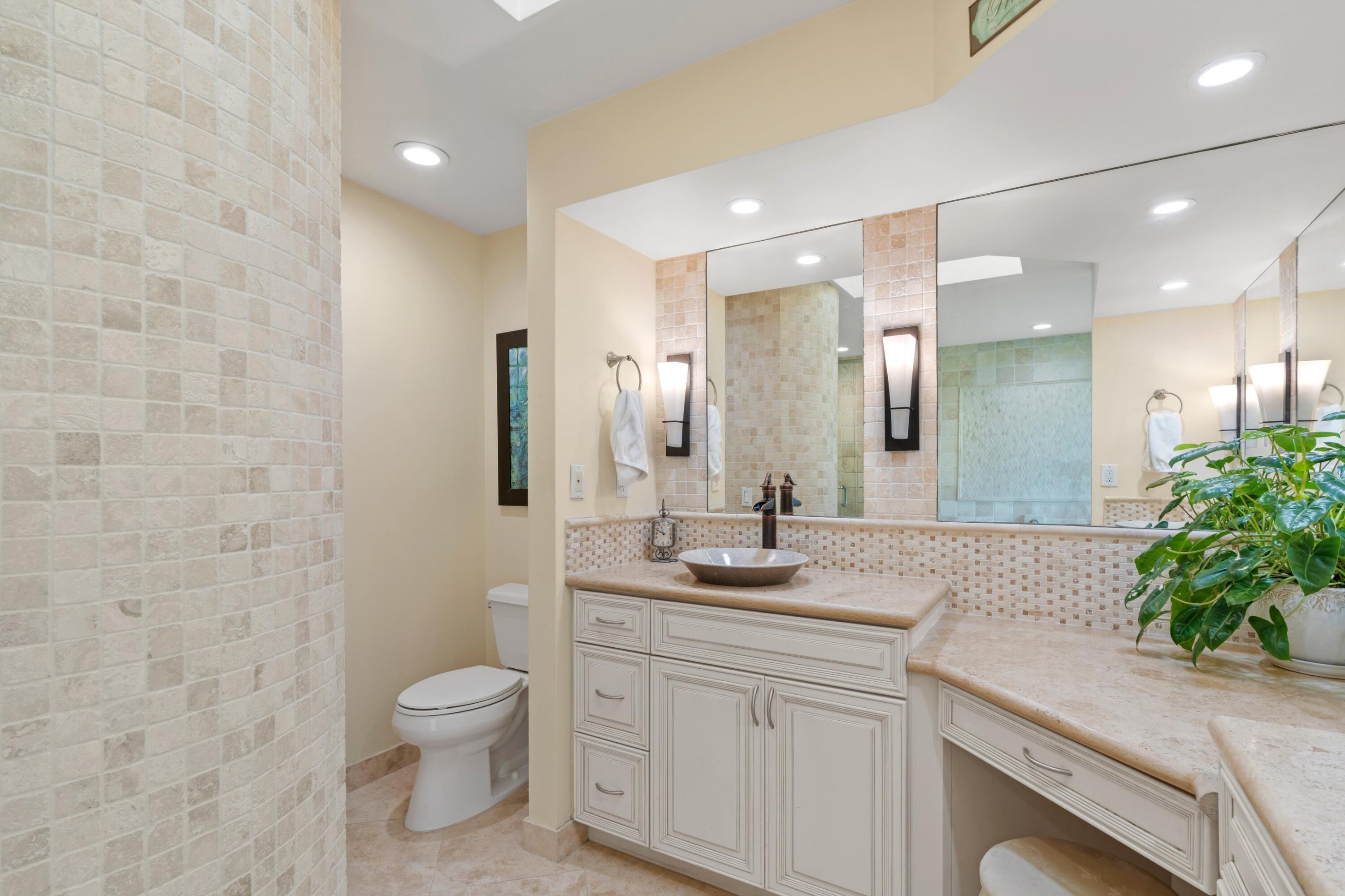 10238 Crosswind Road Boca Raton, FL 33498 - Photo 18 of 42 a bathroom with a granite countertop sink a toilet and a mirror