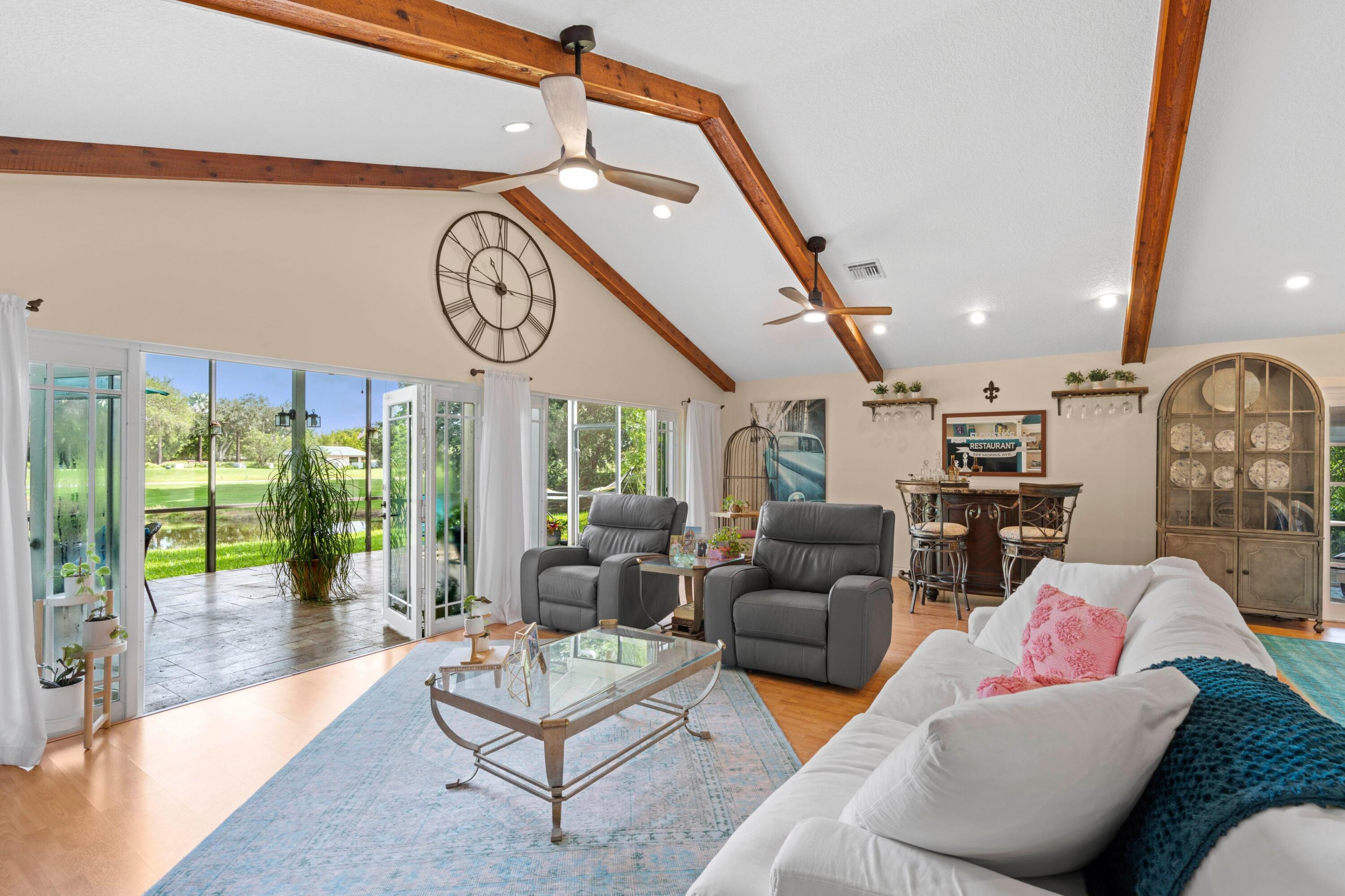 10238 Crosswind Road Boca Raton, FL 33498 - Photo 7 of 42 a living room with furniture a large window and a clock