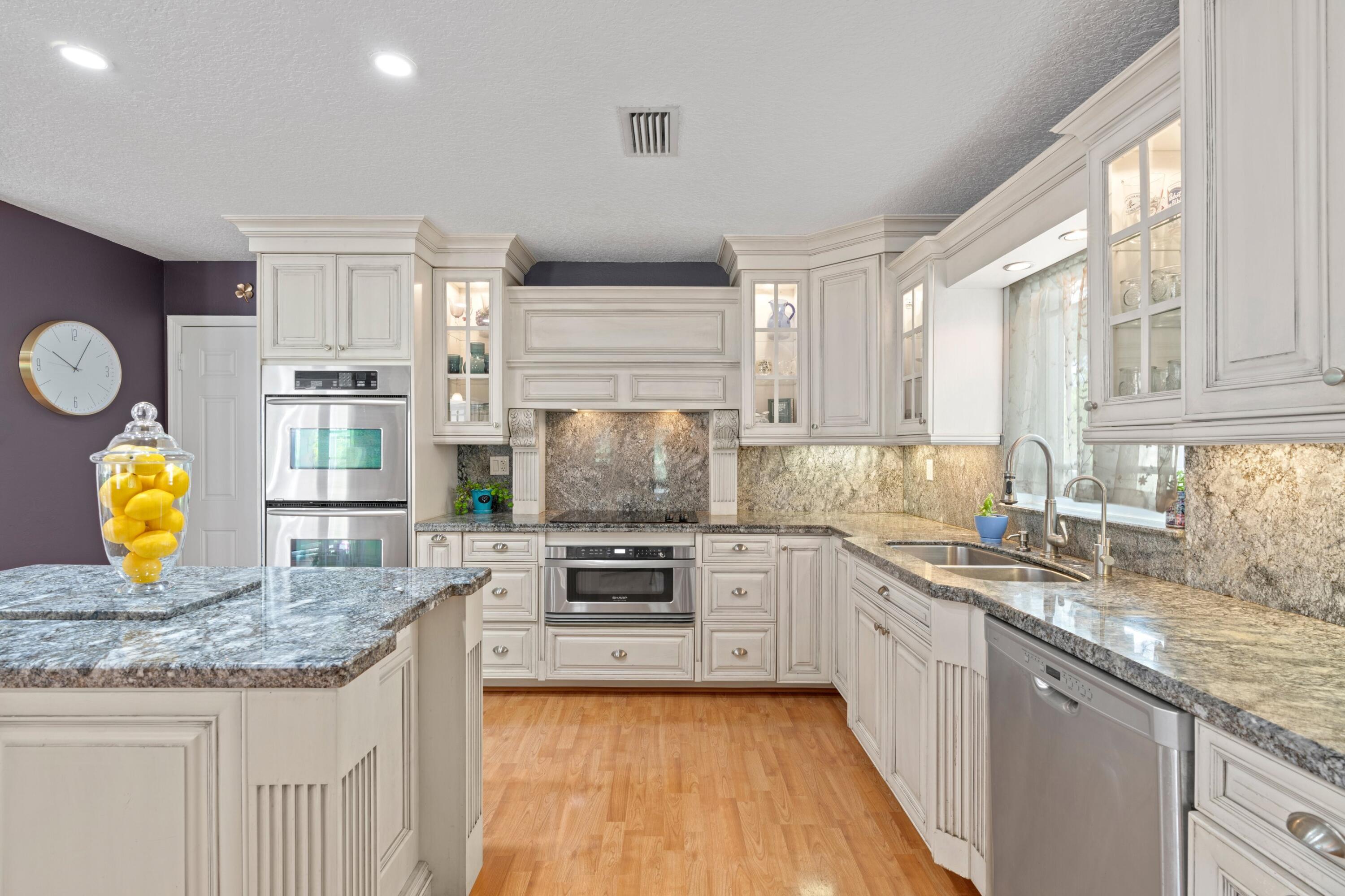 10238 Crosswind Road Boca Raton, FL 33498 - Photo 9 of 42 a kitchen with stainless steel appliances granite countertop a stove and cabinets
